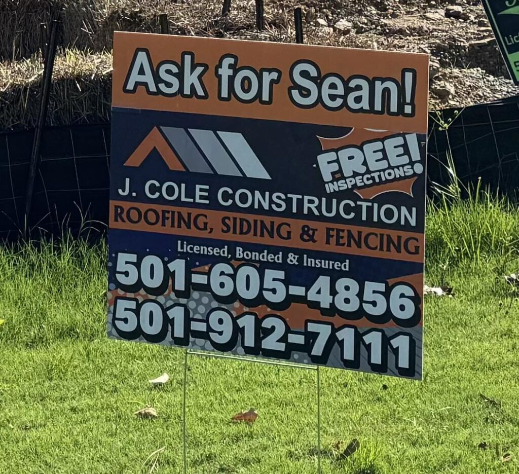 J Cole Roofing & Construction yard sign advertising roofing, siding, and fencing services in Austin AR