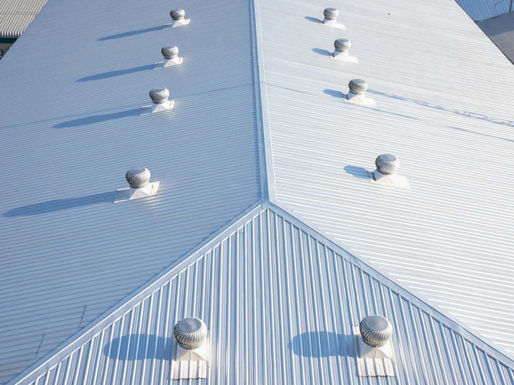 Commercial metal roofing system with ridge vents installed by J Cole Roofing & Construction in Austin AR