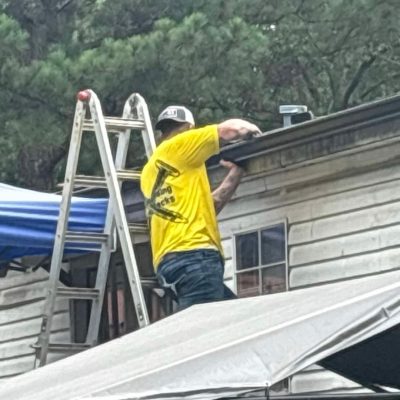 Roofing contractor working on gutter and roof edge by J Cole Roofing & Construction in Austin AR