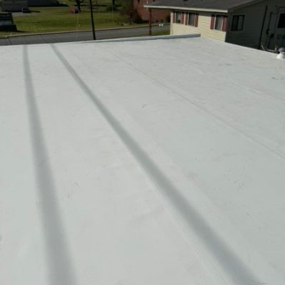 Wide view of a white TPO flat roofing system installed on a residential or commercial property by J Cole Construction